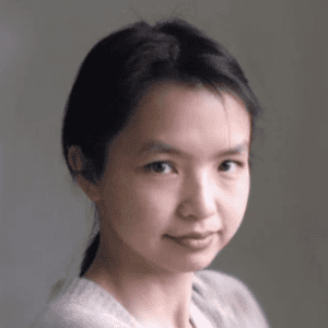 Headshot, smiling wearing a light sweater.