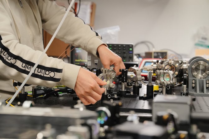Someone's hands can be seen adjusting a mechanical device.
